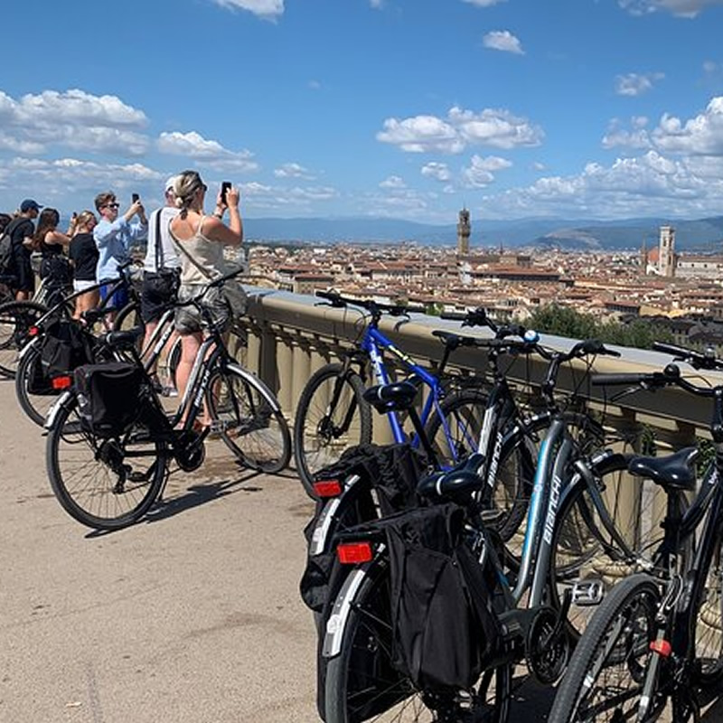 Jóvenes en bicicleta fotografiando el panorama de Florencia